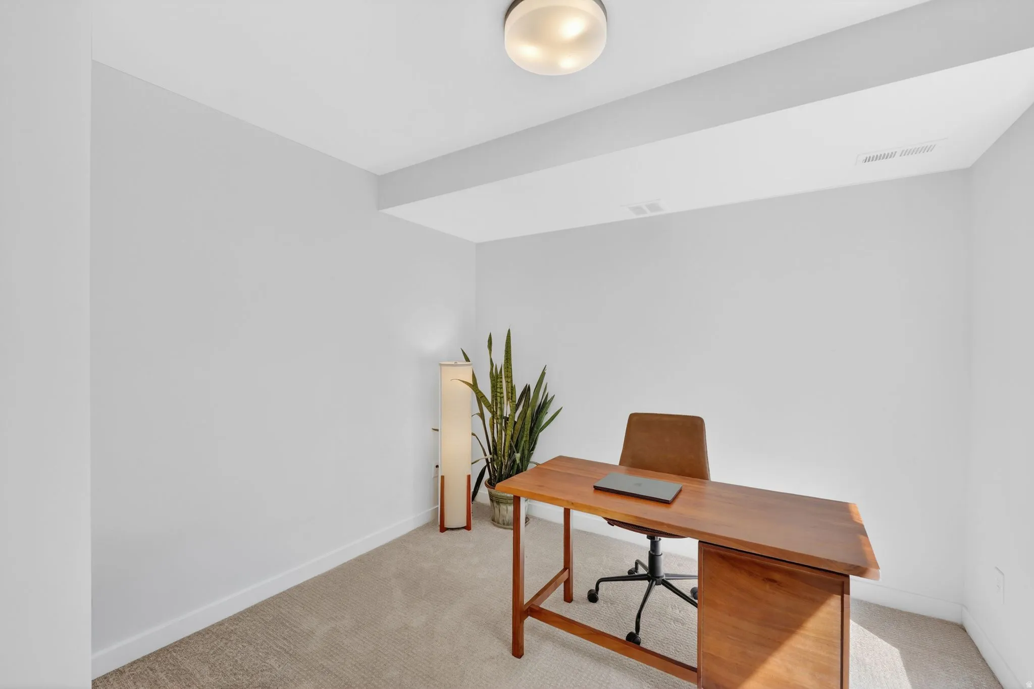 Versatile room featuring light-toned carpeting and neutral wall tones