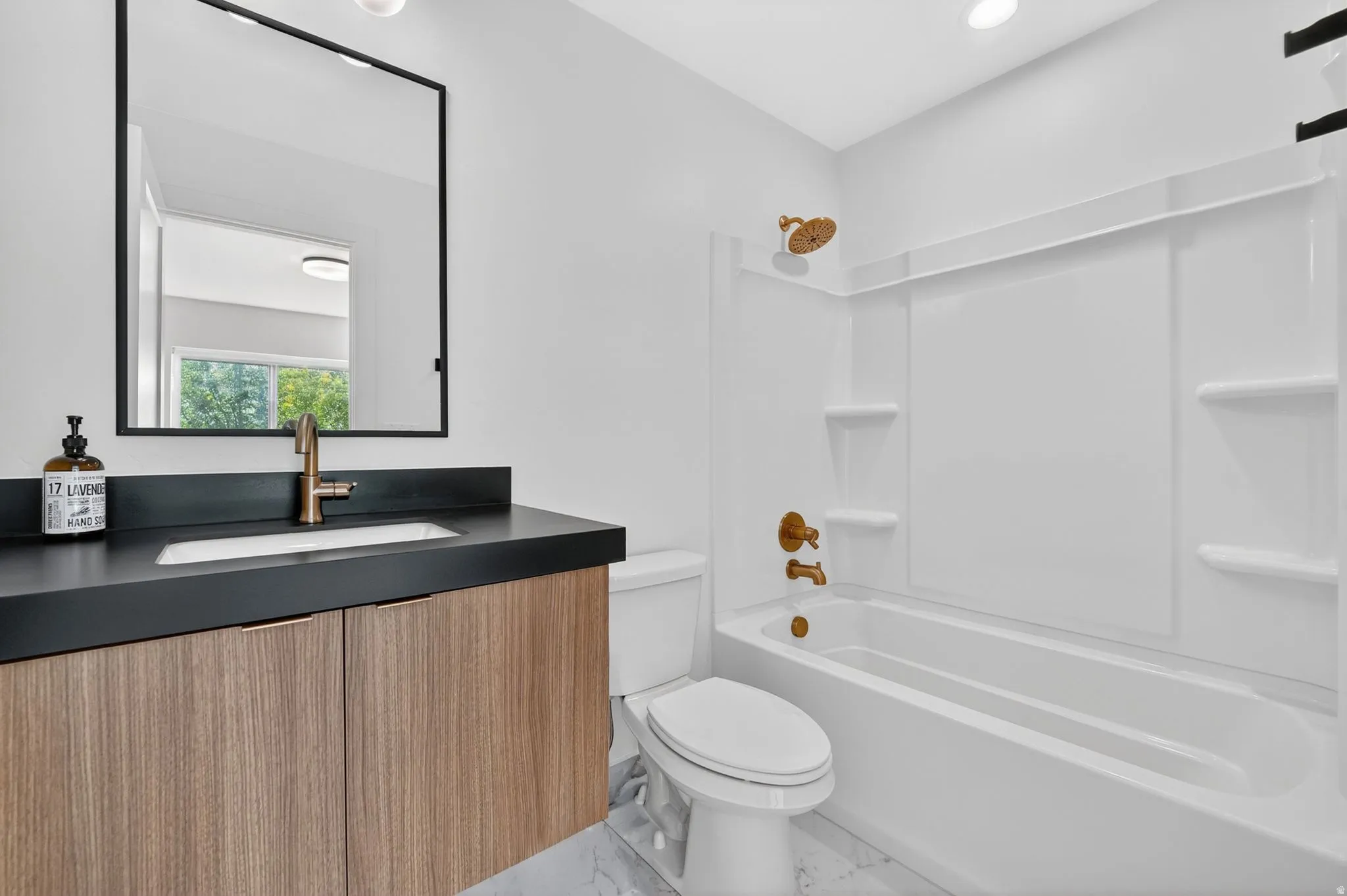 Full bathroom featuring a single floating vanity with wood-finish cabinetry and a dark countertop