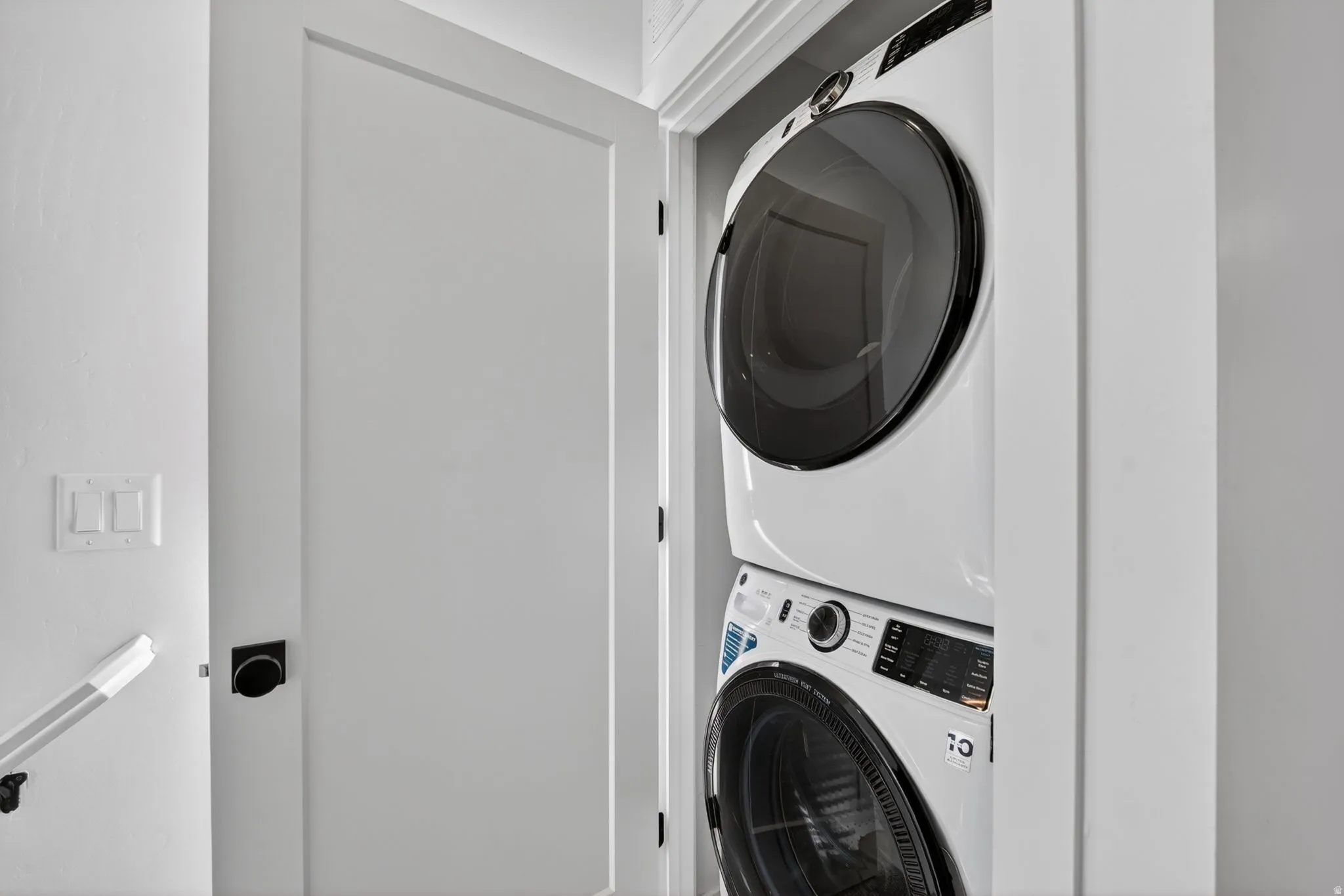 Integrated laundry closet with stacked white washer and dryer units