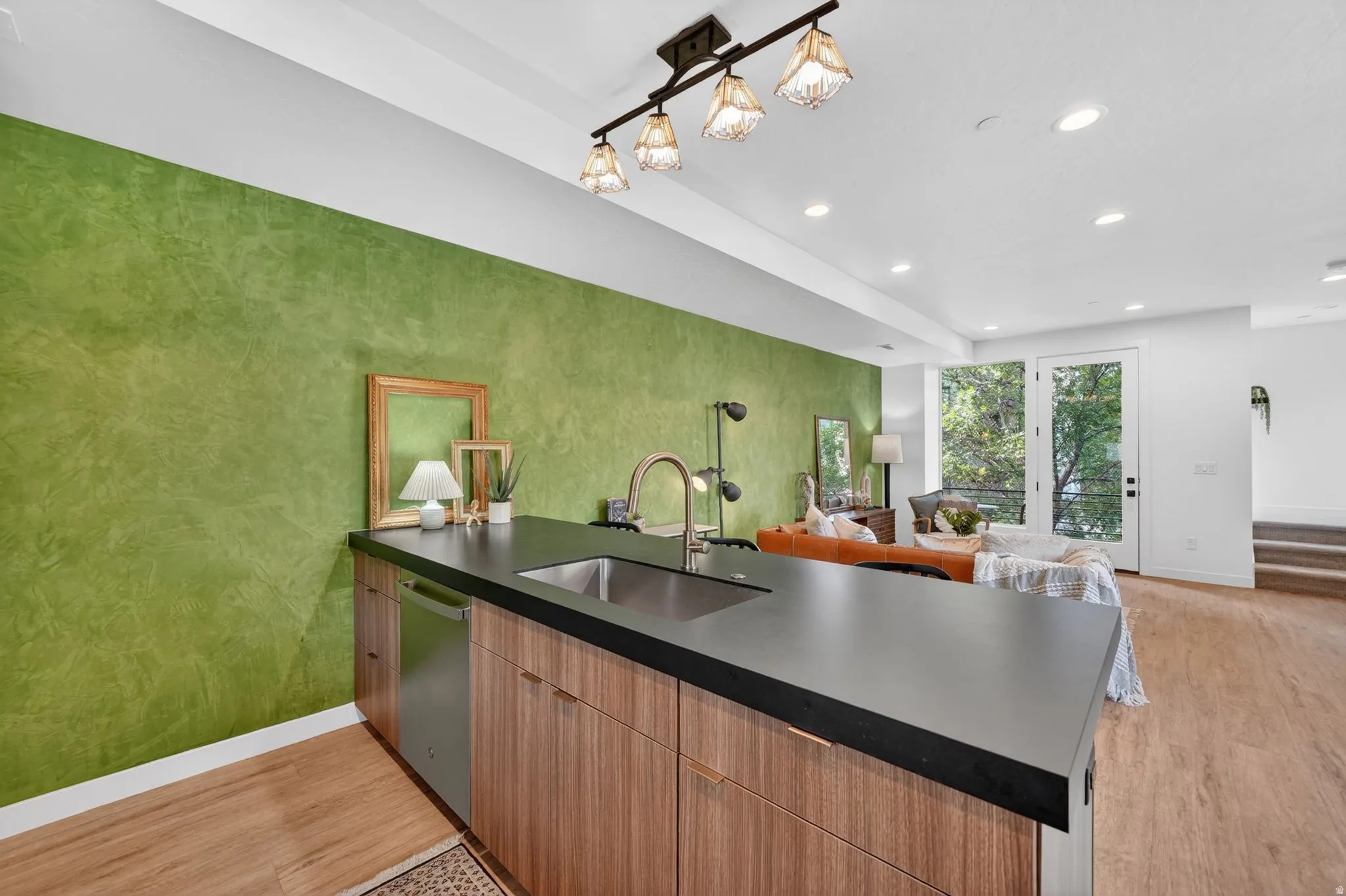 Kitchen island with a dark countertop and undermount sink
