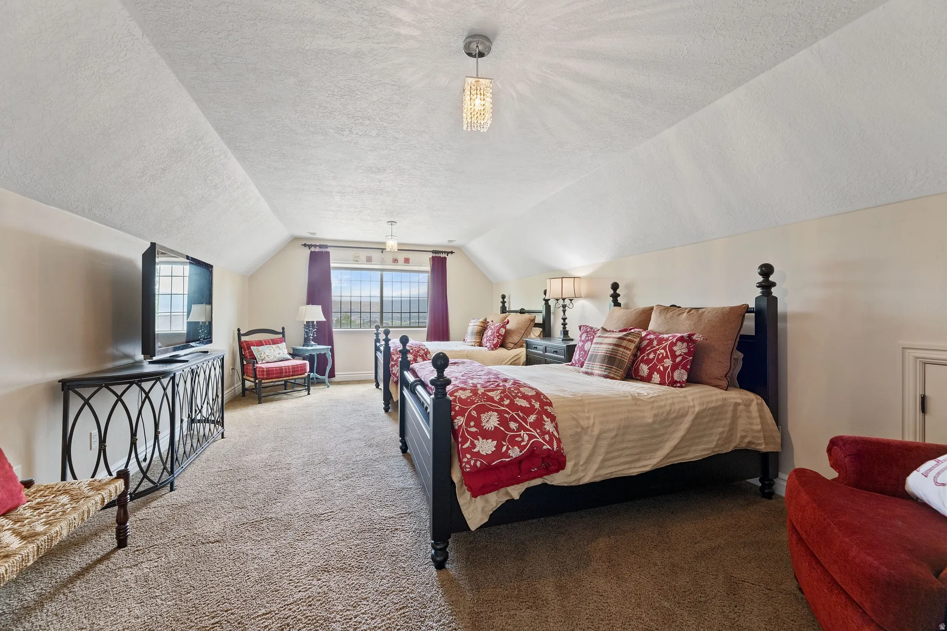 Spacious room featuring sloped ceilings, two large windows, and wall-to-wall carpeting, large walk-in closet