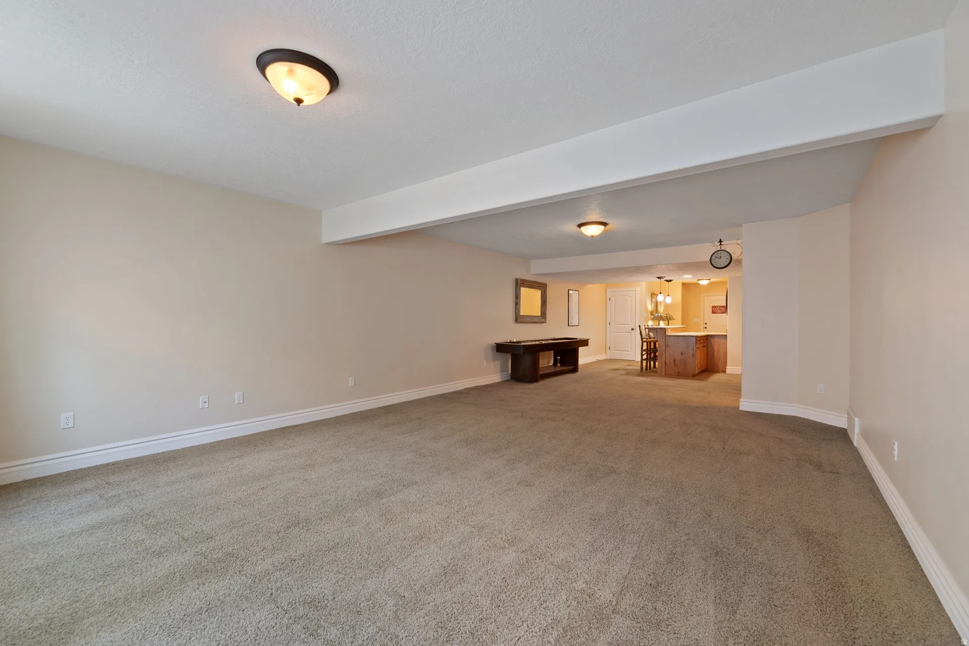 Spacious open-concept room featuring neutral carpet flooring, light-toned walls, and recessed lighting