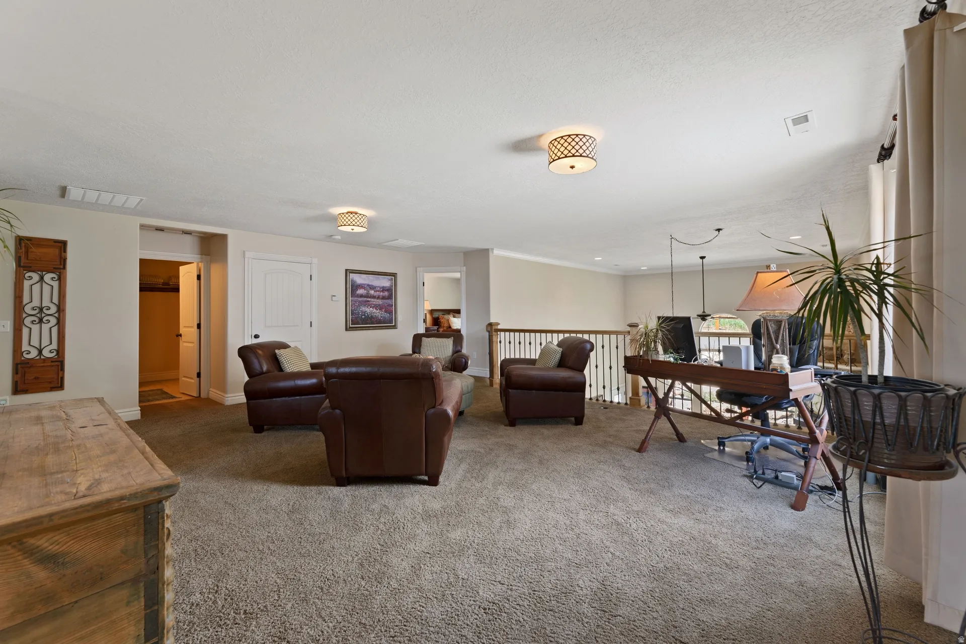 Spacious open-concept room featuring neutral-toned carpet flooring, light beige wall paint, and white trim