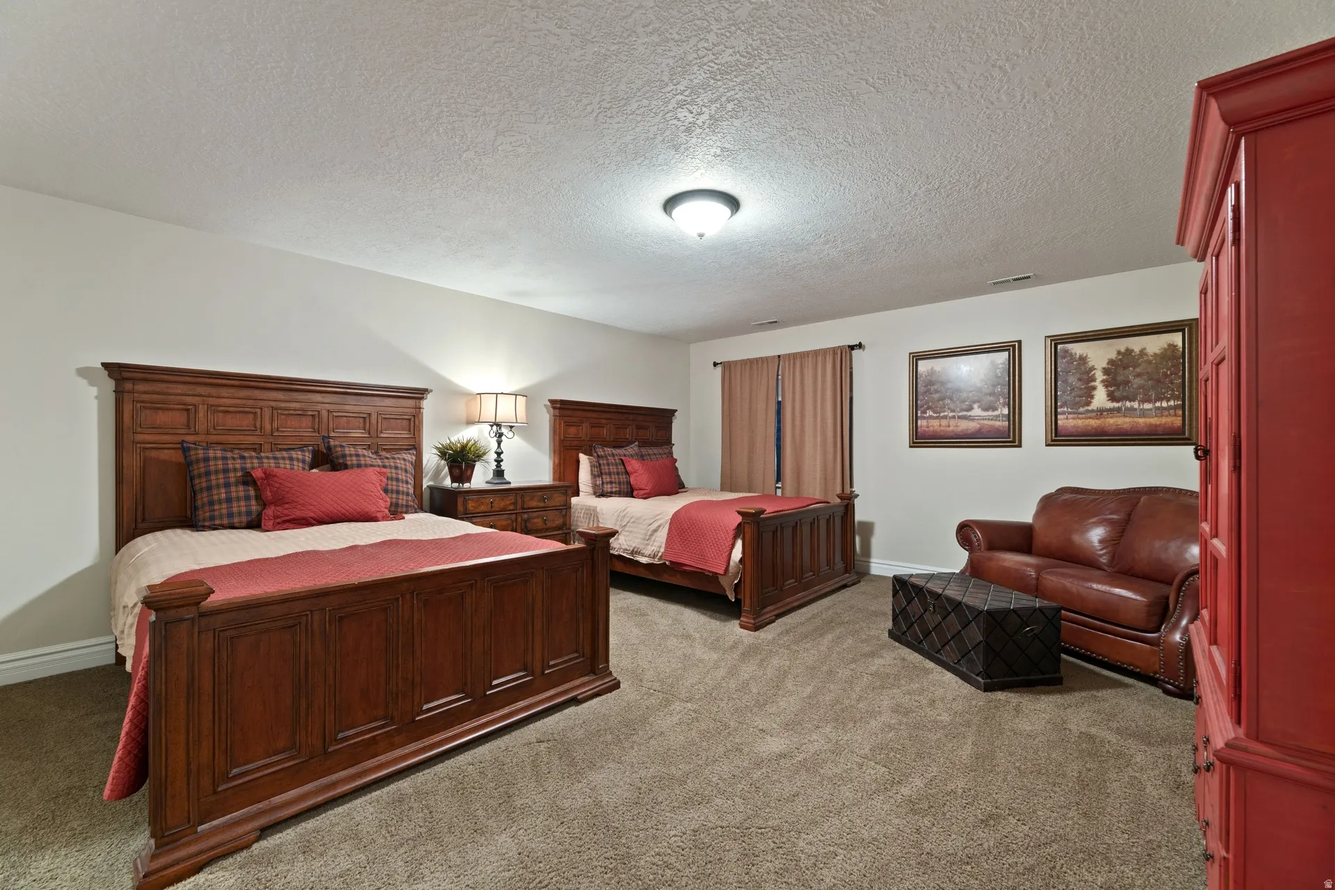 Spacious guest bedroom featuring neutral wall tones and plush carpet flooring, plus huge walk-in closet