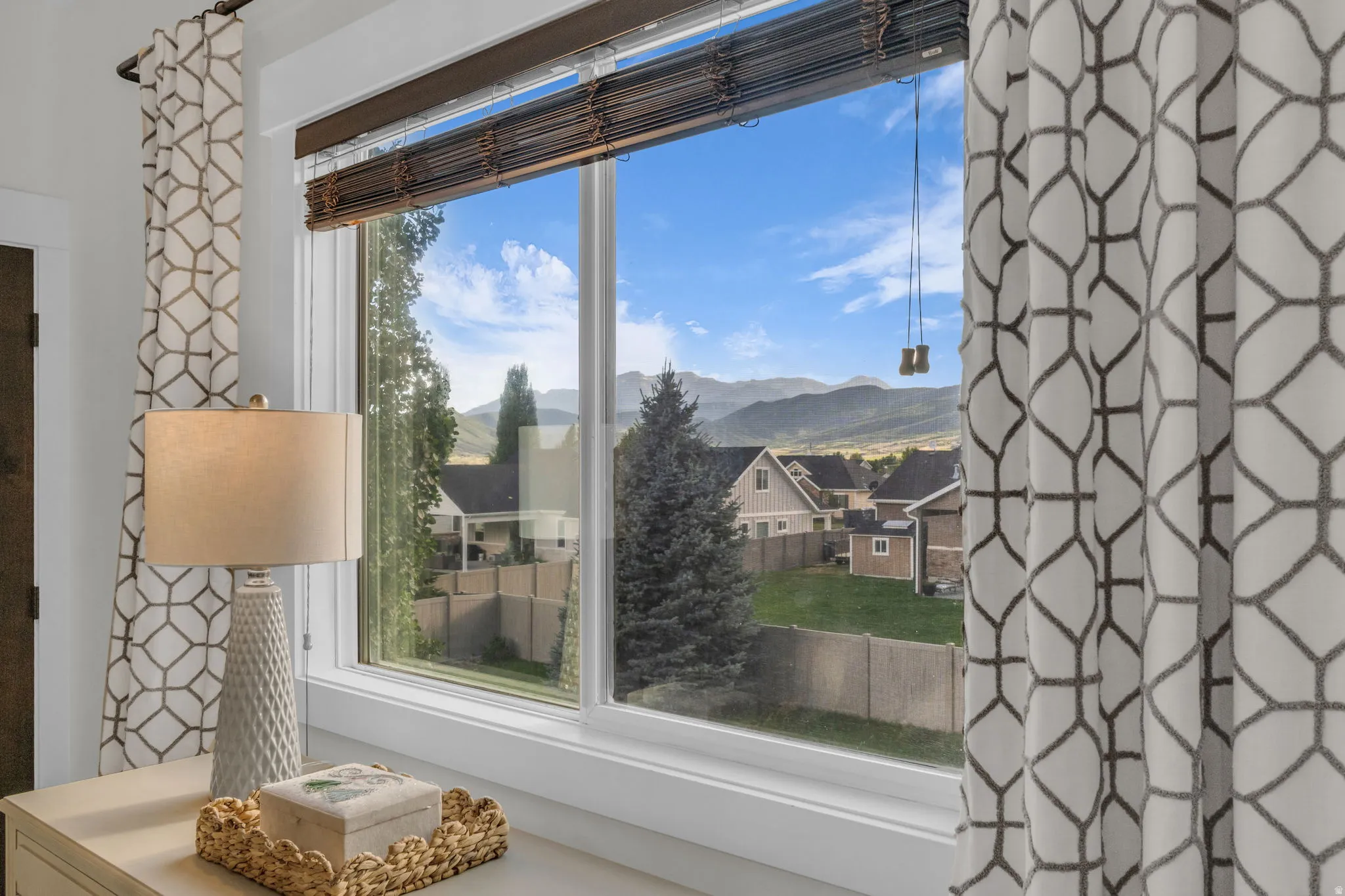 Large window framing a Timpanogos view featuring white trim and a dark wood blind