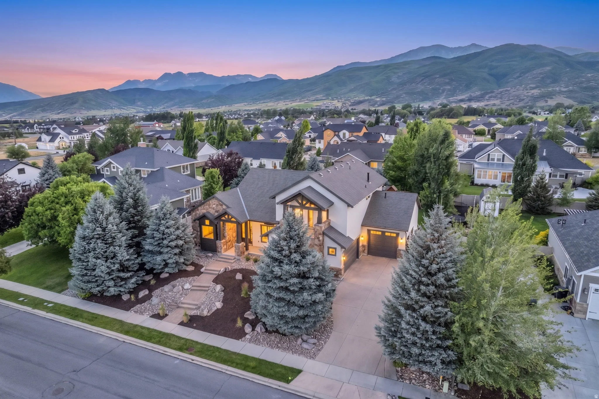 Custom home with stone and stucco exterior, featuring a multi-gable roofline and prominent entry