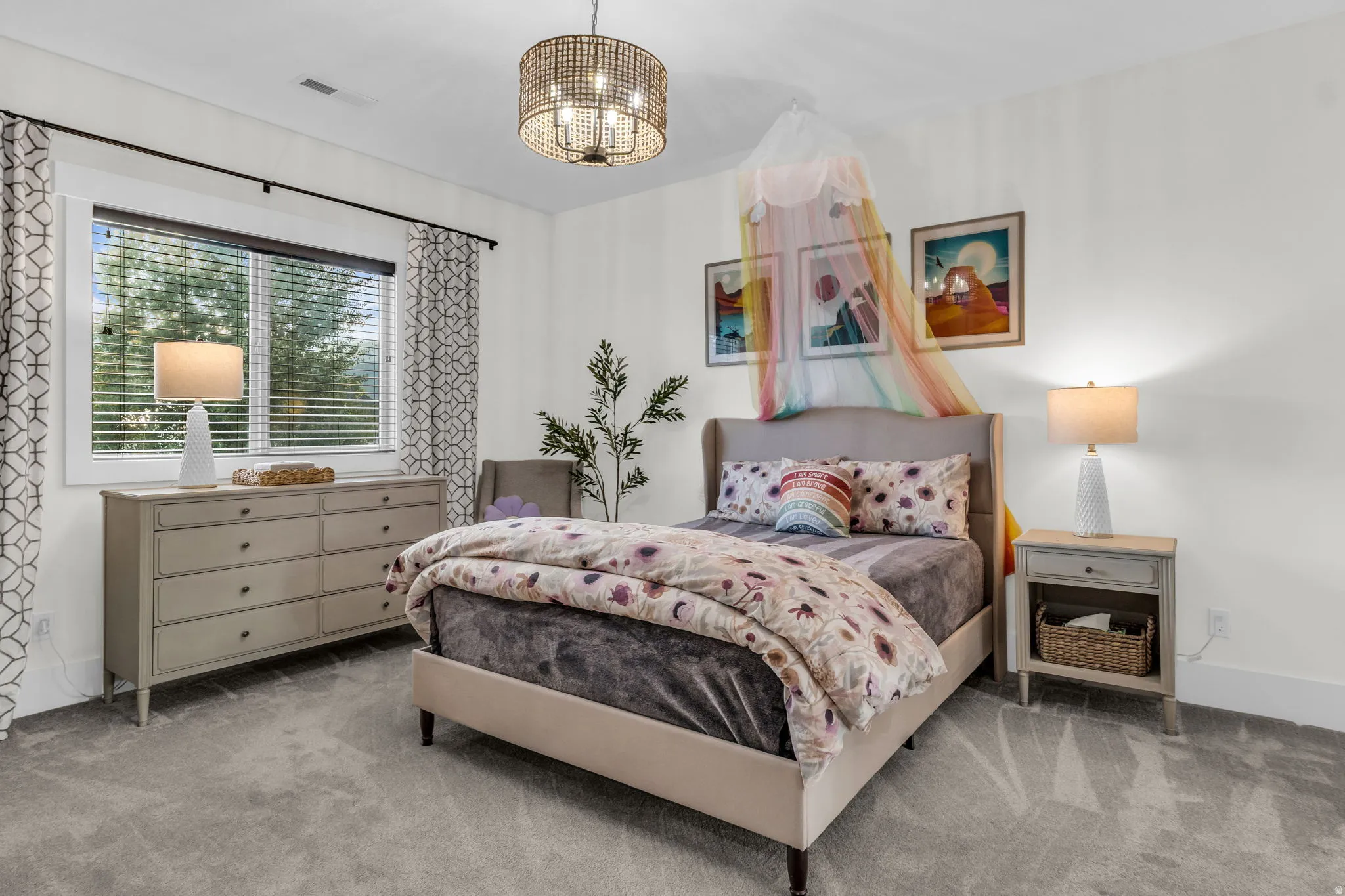 Spacious bedroom featuring plush gray carpeting, a large window with blinds, and white walls