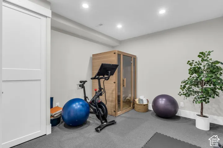 Dedicated wellness space featuring a built-in sauna, neutral wall paint, recessed lighting, and grey carpet flooring