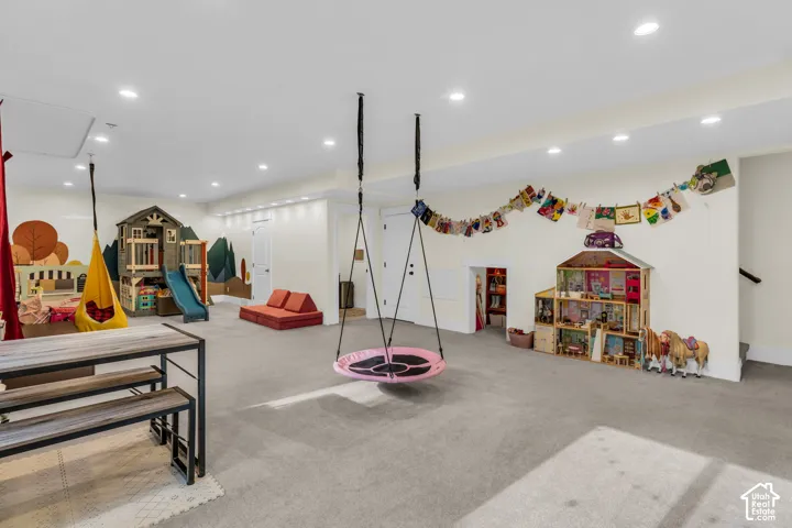 Spacious room featuring light gray carpet flooring and recessed ceiling lights
