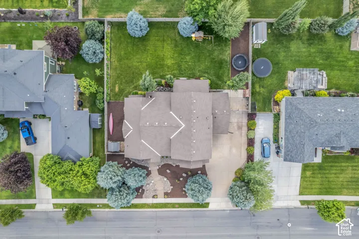 Aerial perspective highlighting a residential property with a multi-gabled roofline and an expansive front driveway