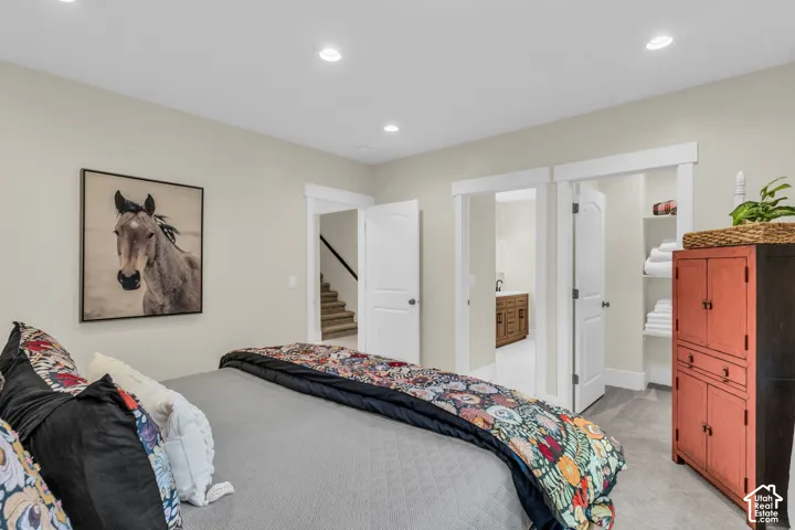 Recessed lighting illuminates the carpeted room, featuring solid core doors with white trim