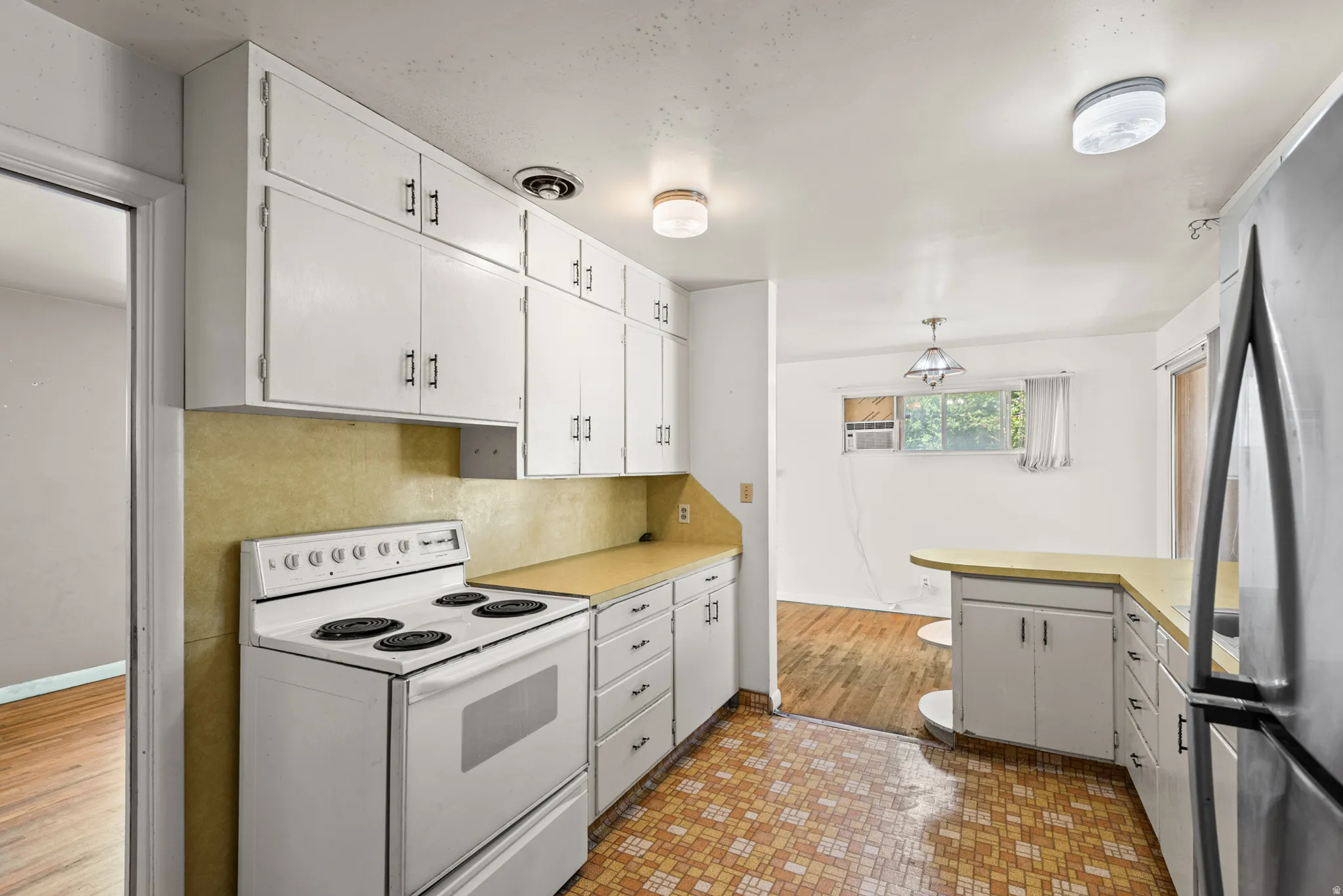 Kitchen featuring white cabinetry and a white freestanding range