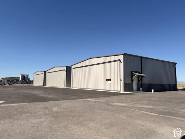 Three metal industrial buildings featuring roll-up doors and a paved lot
