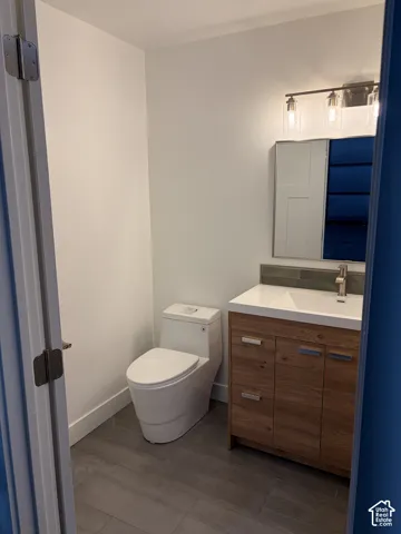 Modern bathroom featuring wood-finish vanity with drawer and cabinet storage