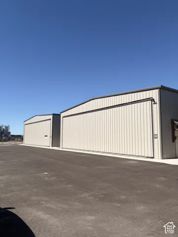 Two corrugated metal structures with coordinating metal trim and gabled roofs