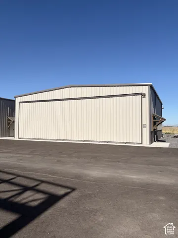 Large commercial-style building featuring metal siding and a wide hangar door