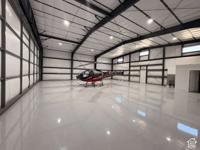 Spacious hangar featuring a high-gloss, light gray epoxy floor and exposed metal beam construction