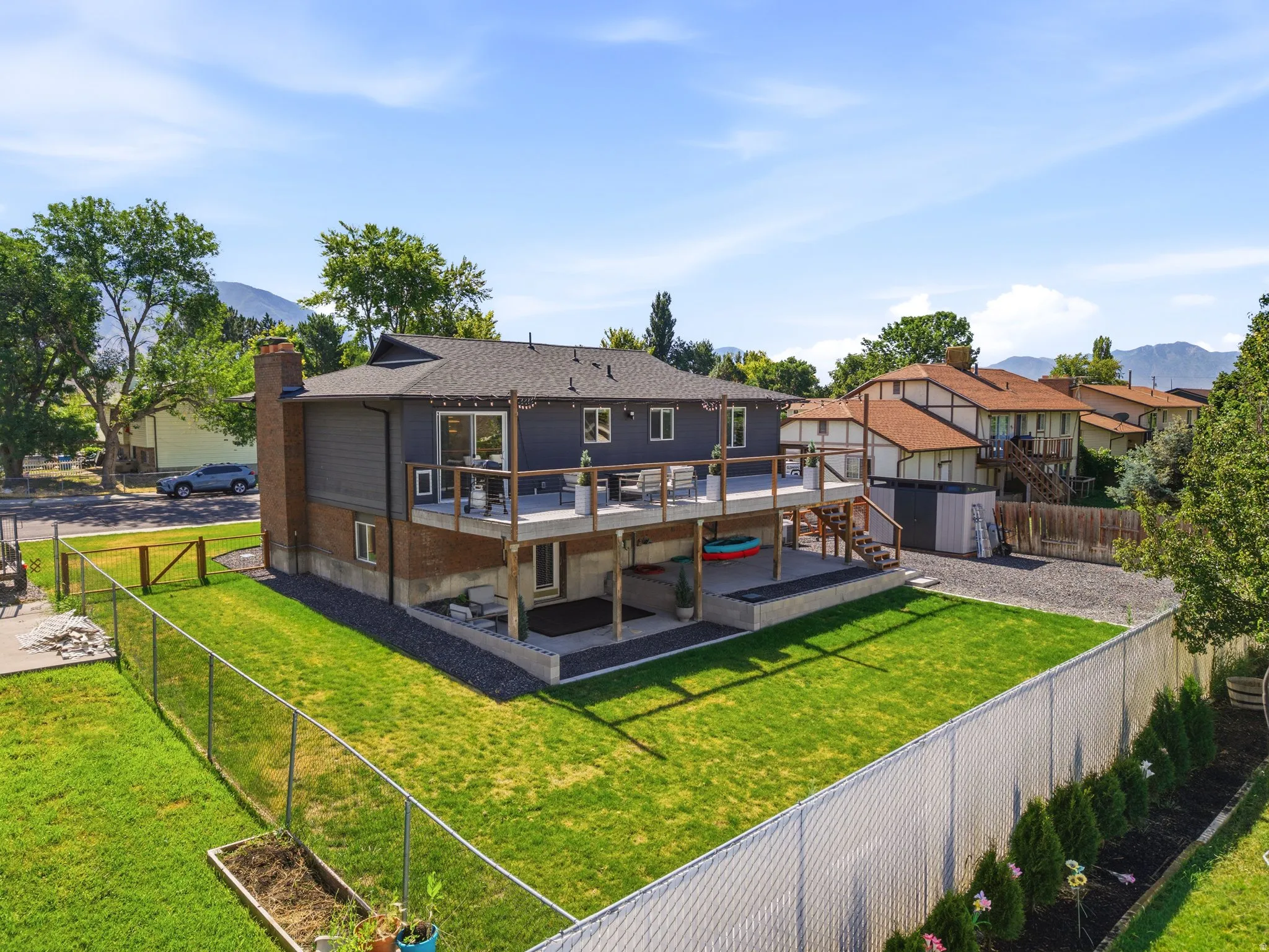 Split-level residence featuring a spacious elevated deck and an expansive, fenced backyard