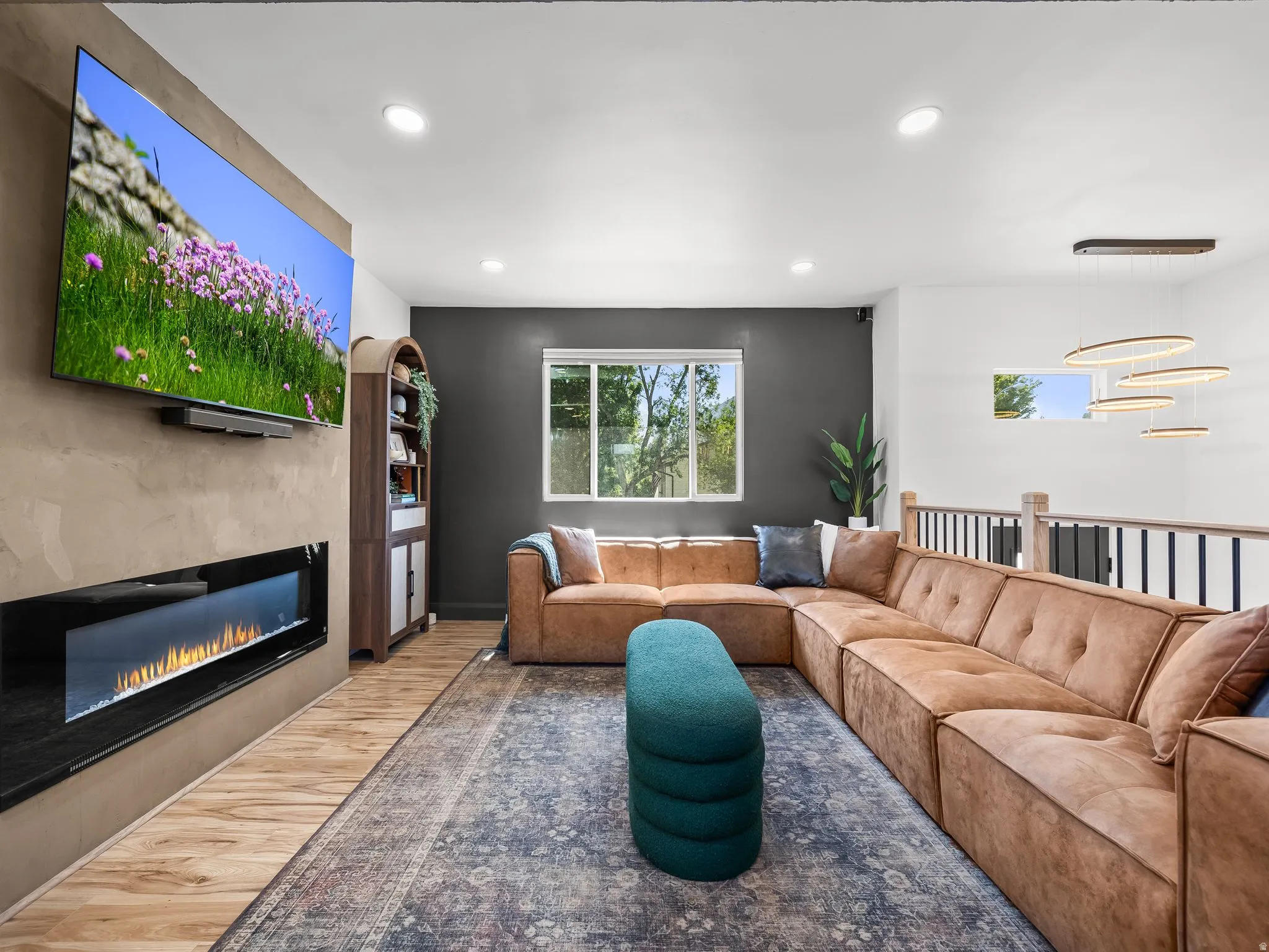 Living area featuring a contemporary linear fireplace, recessed lighting, and wood-finish flooring