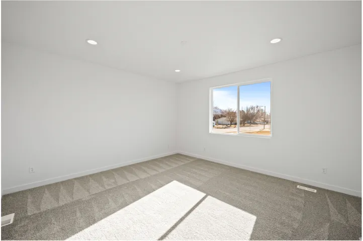 Spacious room featuring neutral carpeting and white walls