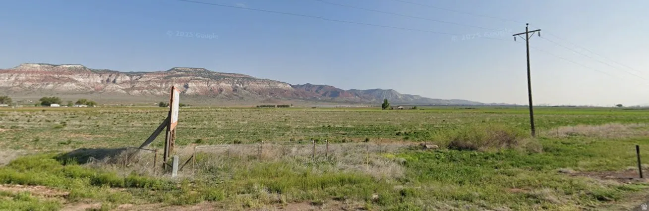 Expansive open land with distant mountain ranges and a clear sky