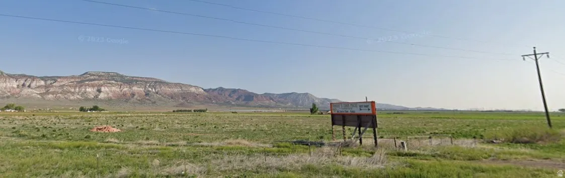 Expansive open field with distant mountains and a clear sky