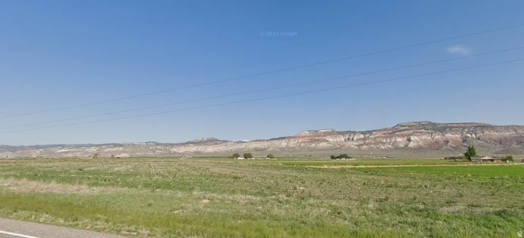 Expansive open land with distant mountainous terrain under a clear sky