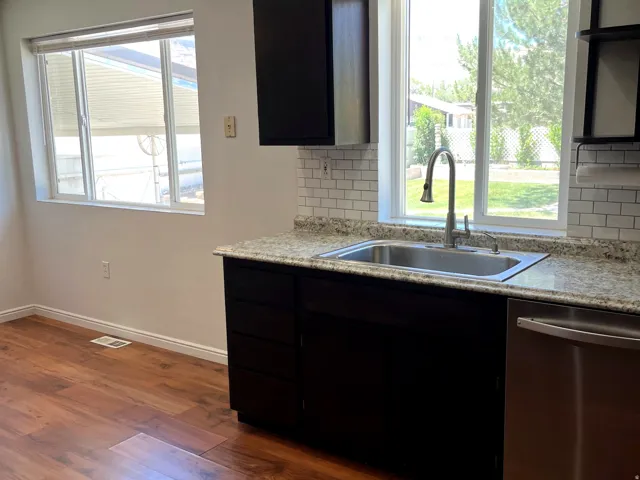Kitchen area featuring wood-finish flooring and white walls