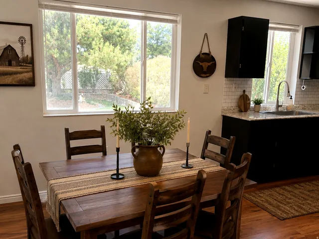 Dining area featuring wood-finish flooring, a wooden dining table, and direct window access