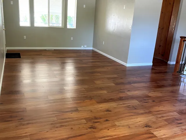 Expansive room featuring wood-finish flooring, light neutral wall paint, and white trim
