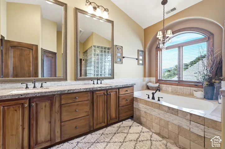 Soaking tub with tiled surround beneath an arched window