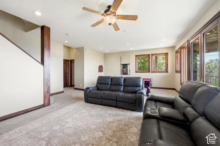Spacious lower-level living area with recessed lighting and a ceiling fan