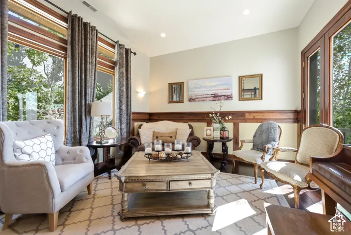 Living area featuring substantial windows, wood trim accents, recessed lighting, and a neutral color palette