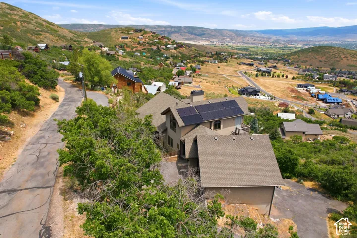 Hillside residence featuring multiple gabled rooflines, a multi-car garage, and solar panels