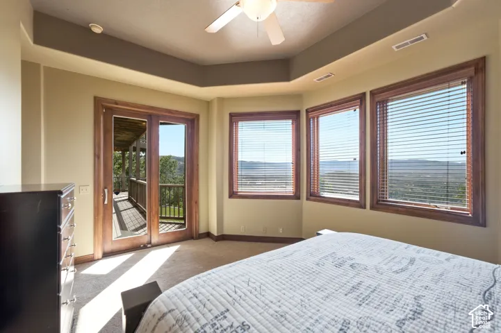 Room featuring a tray ceiling, ceiling fan, carpeted flooring, and light-toned wall paint