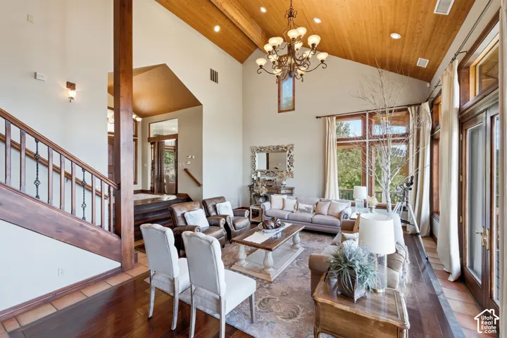 Vaulted wood-paneled ceilings with exposed beams, wood-finish flooring, and a grand staircase with wrought iron balusters