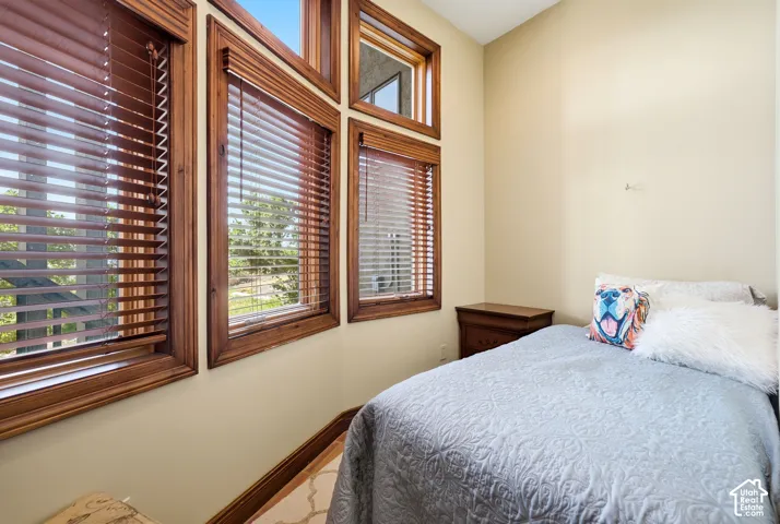 Warm-toned wood window frames with horizontal blinds, complemented by light neutral wall paint