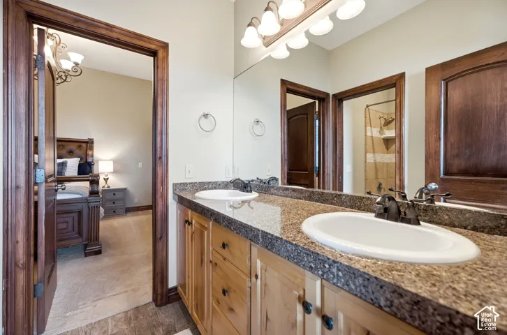Double vanity featuring a speckled countertop, integrated sinks, and bronze-finish faucets