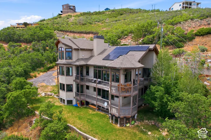 Multi-level residence featuring a stucco exterior and extensive solar panel array