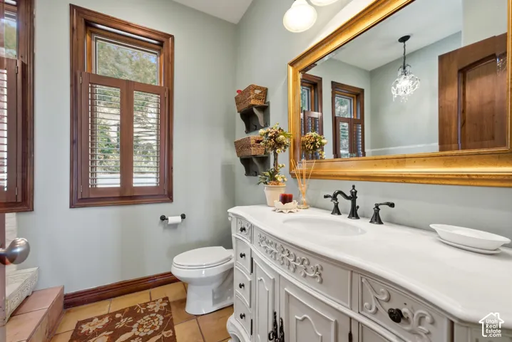 White vanity with ornate detailing and a white countertop with an undermount sink