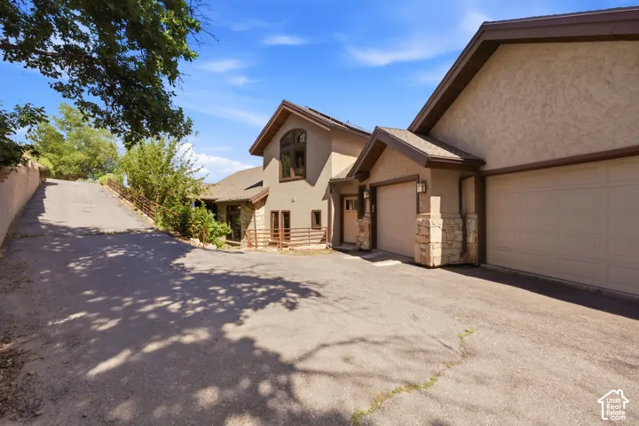 Stucco exterior with stone accents and multiple garage doors