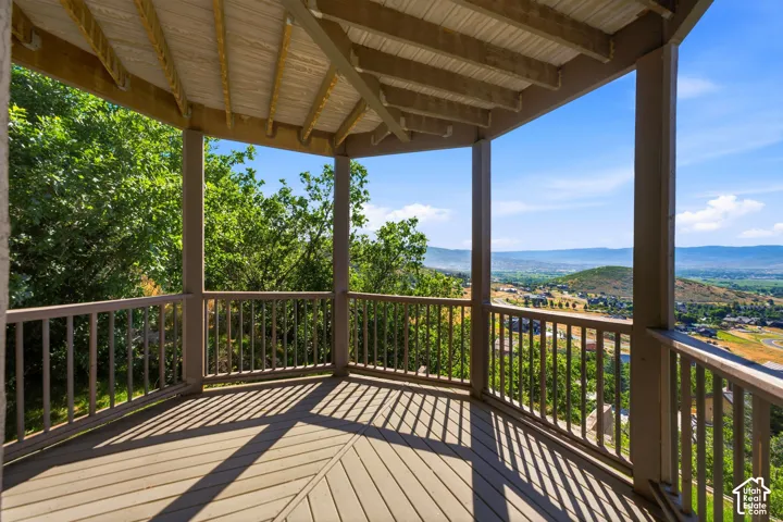 Covered outdoor deck with composite decking, a slatted railing system, and a tongue-and-groove ceiling