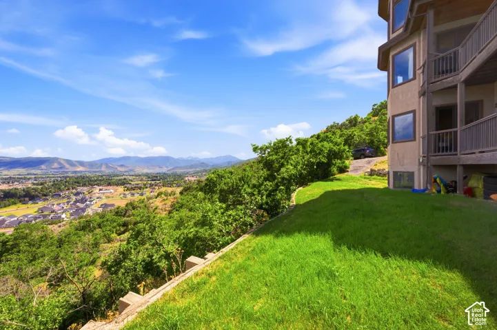 Terraced property with expansive green lawn and distant mountain scenery