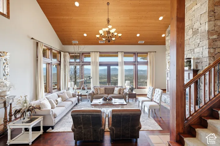 Spacious living area featuring a vaulted wood-paneled ceiling, recessed lighting, and a large multi-pane window array