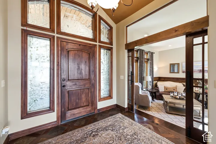 Grand entryway featuring a solid wood door with arched top panel, flanked by two side panels with frosted glass in wood frames