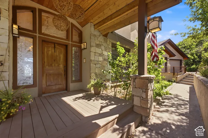 Inviting porch entry featuring a substantial wood door with decorative glass sidelights and transom
