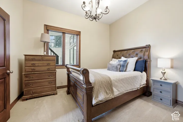 Carpeted room with a dark wood-finish door, matching trim, and a window featuring horizontal blinds