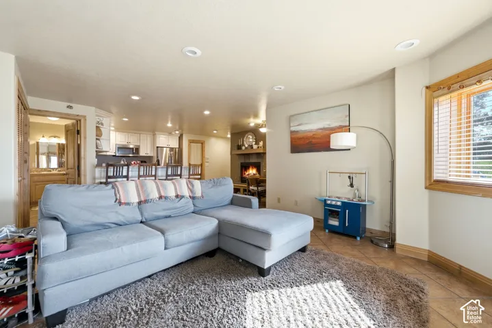 Living area featuring recessed lighting, a window with wood trim, and tile flooring