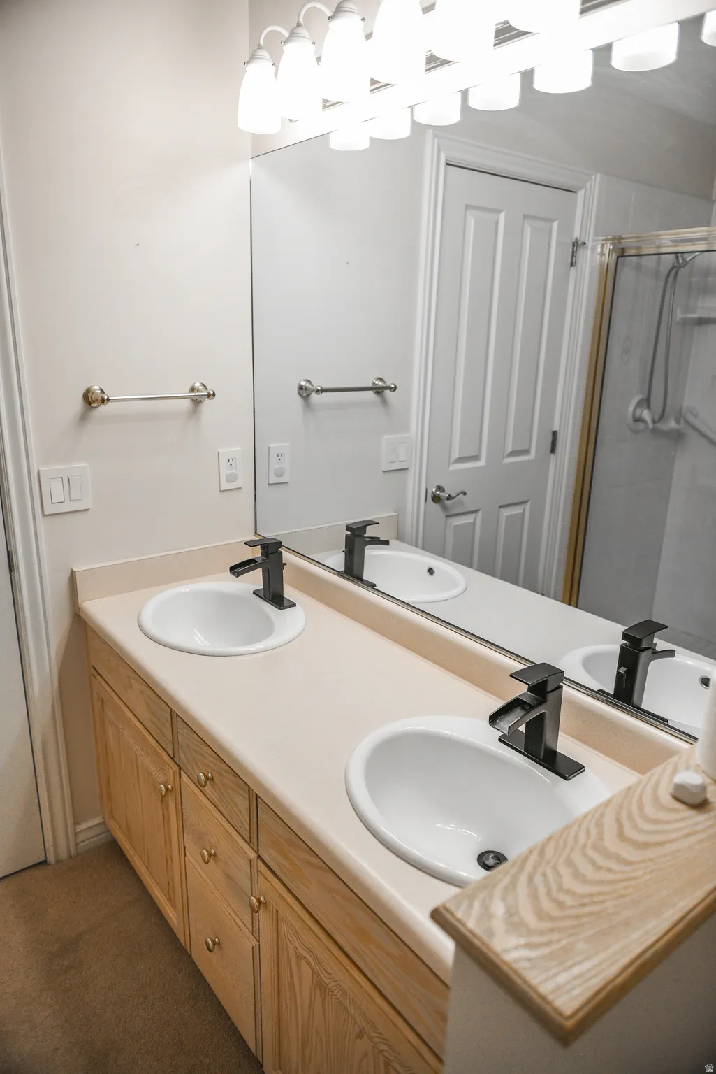 Double vanity featuring integrated sinks, light-toned countertop, and matte black faucets