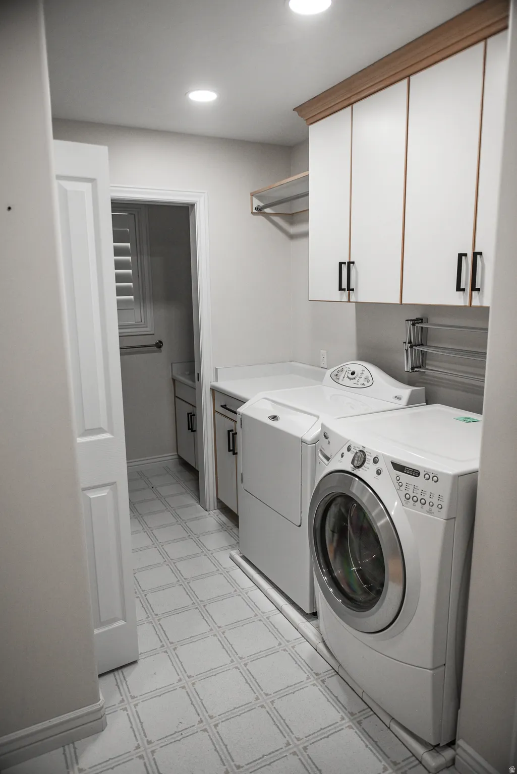 Laundry area featuring tile flooring, built-in cabinetry, and recessed lighting